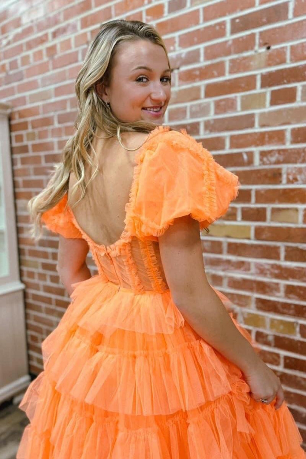 Robe de bal longue en tulle à épaules dénudées, coupe trapèze, bustier à volants et fente.