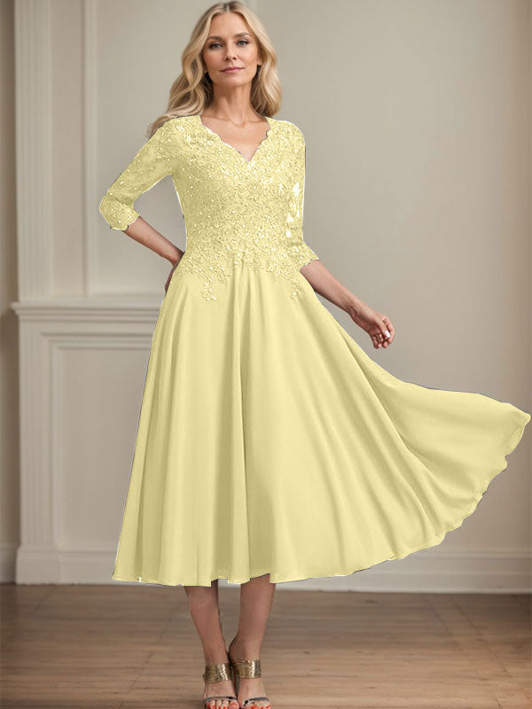 Vestido de corte A, escote en V, largo hasta la rodilla, de gasa, encaje, con lentejuelas y pedrería para la madre de la novia. 