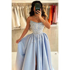 Vestido largo de fiesta azul satinado sin tirantes con cuentas y corte en A, con abertura. 
