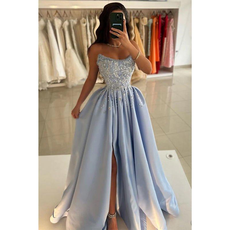 Vestido largo de fiesta azul satinado sin tirantes con cuentas y corte en A, con abertura. 