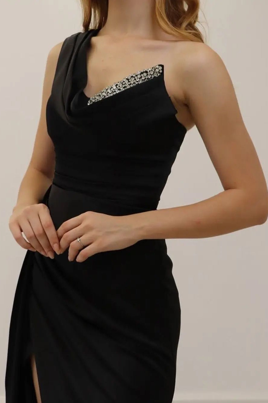 Vestido de fiesta negro de corte A, asimétrico, sin mangas, con lentejuelas y abertura.