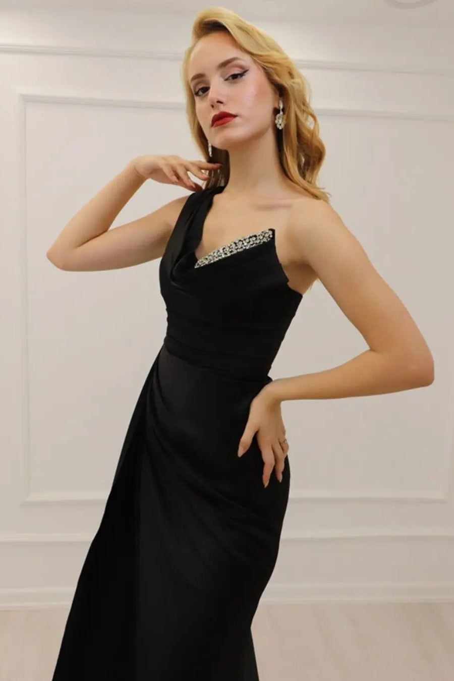 Vestido de fiesta negro de corte A, asimétrico, sin mangas, con lentejuelas y abertura.