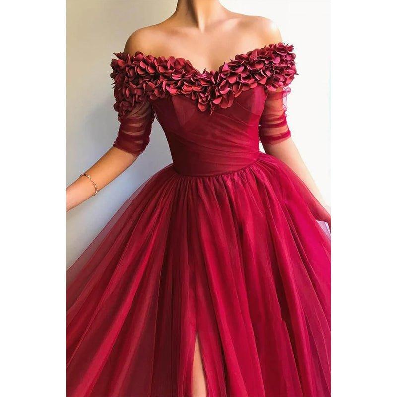 Vestido largo de noche formal, corte en A, de tul burdeos, con hombros descubiertos, apliques y abertura. 