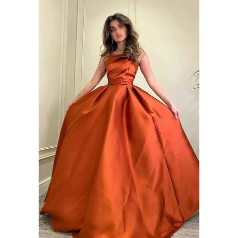 Vestido de fiesta formal clásico y atemporal de corte en A, sin mangas, con hombros descubiertos y fruncido.