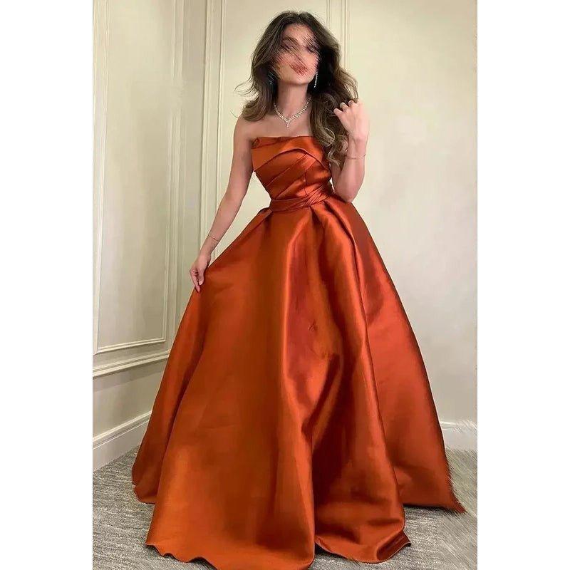 Vestido de fiesta formal clásico y atemporal de corte en A, sin mangas, con hombros descubiertos y fruncido.