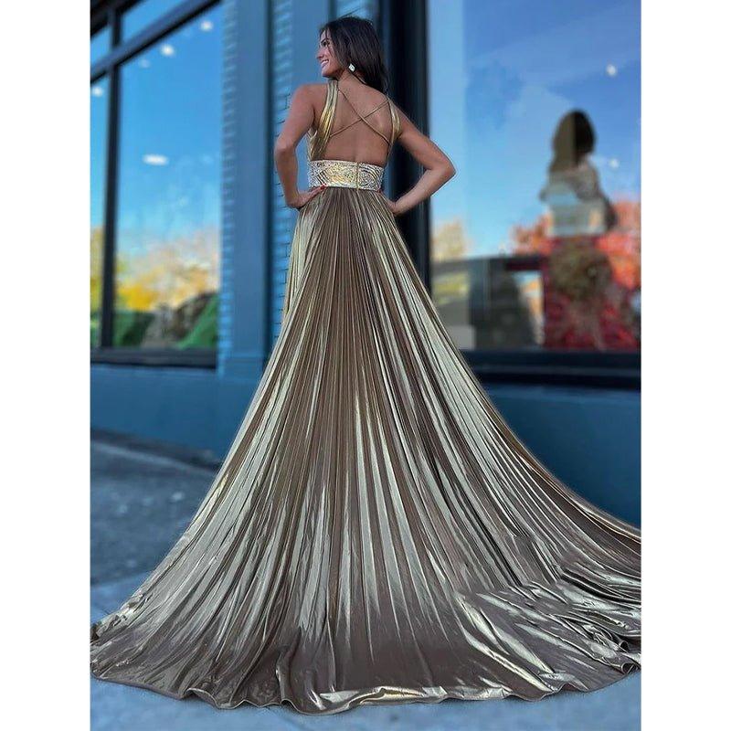 Vestido largo de noche color champán con tirantes cruzados, corte en A y cola de barrido. 