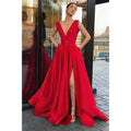 Vestido largo de fiesta rojo satinado de corte evasé, escote en V profundo, abertura alta y bolsillos. 