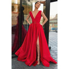 Vestido largo de fiesta rojo satinado de corte evasé, escote en V profundo, abertura alta y bolsillos. 