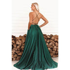 Vestido largo de fiesta verde satinado de corte A con escote redondo, abertura alta y bolsillos. 
