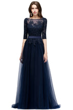 Vestido de fiesta de tul con apliques, corte en A, manga tres cuartos, largo hasta el suelo y abertura lateral, con fajín.
