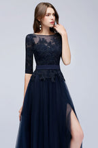 Vestido de fiesta de tul con apliques, corte en A, manga tres cuartos, largo hasta el suelo y abertura lateral, con fajín.