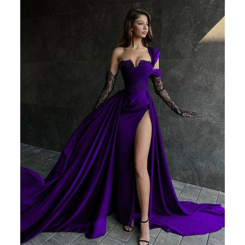 Robe de bal longue noire fendue sur le haut, coupe trapèze, ornée de dentelle et d'appliques.