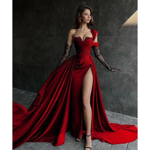 Robe de bal longue noire fendue sur le haut, coupe trapèze, ornée de dentelle et d'appliques.