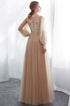 Vestido de noche de tul color champán con apliques, manga larga y corte en A