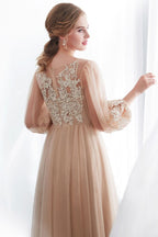 Vestido de noche de tul color champán con apliques, manga larga y corte en A