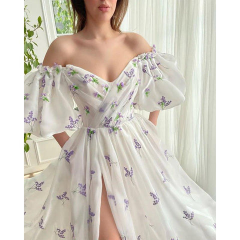 Vestido largo de fiesta con escote barco, abertura lateral y bolsillos. 