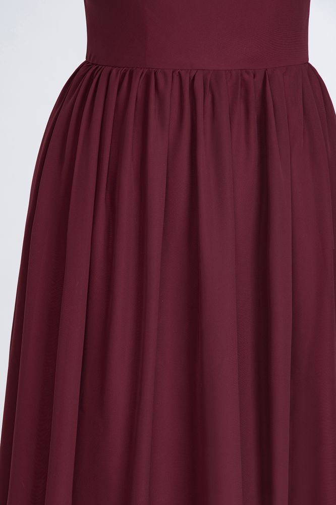 Vestido de dama de honor de corte A, asimétrico, sin mangas, con volantes y bordado de cuentas. Largo hasta el suelo.