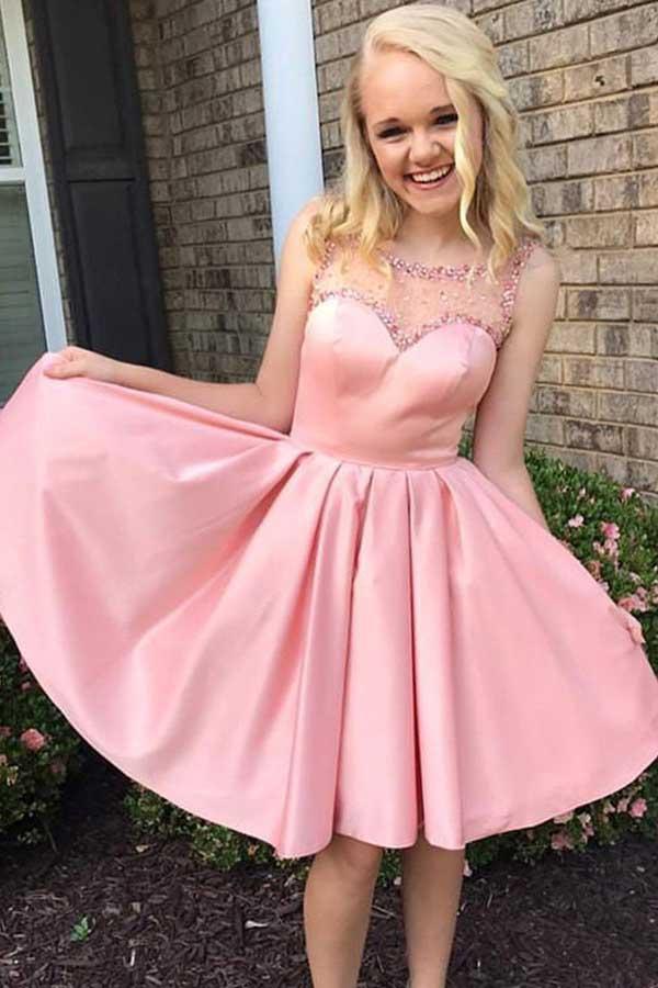 Vestido rosa satinado de corte evasé con cuello redondo, ideal para fiestas o bailes de bienvenida, con detalles de pedrería (PD079)