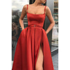 Vestido largo de fiesta rojo satinado con escote en A, tirantes finos, abertura alta y bolsillos. 