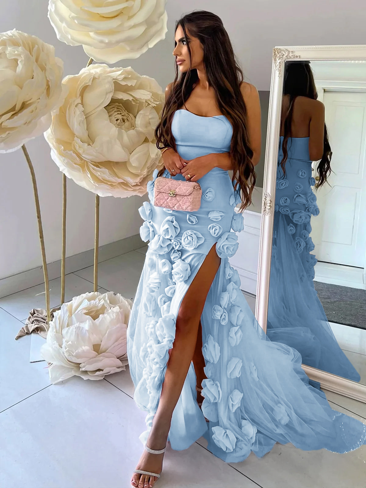 Vestido de fiesta rosa con escote corazón, sin mangas, corte asimétrico y flores.