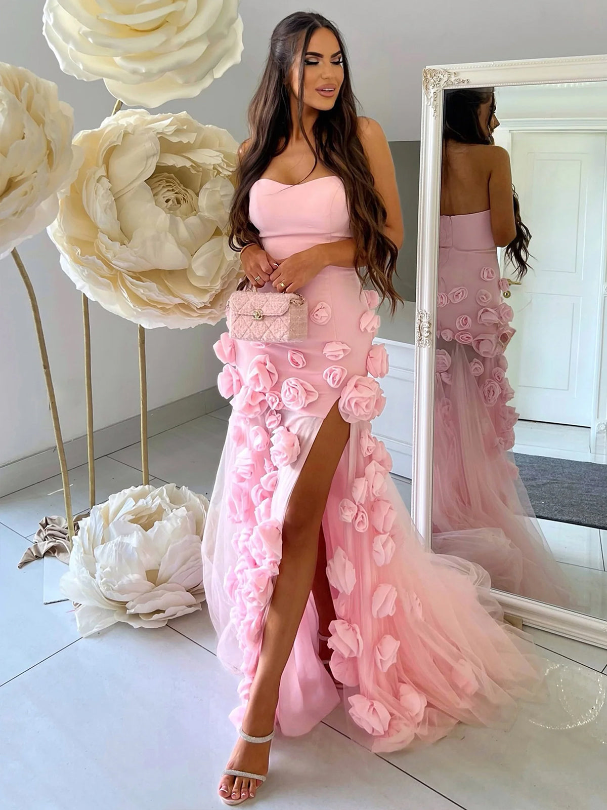 Vestido de fiesta rosa con escote corazón, sin mangas, corte asimétrico y flores.
