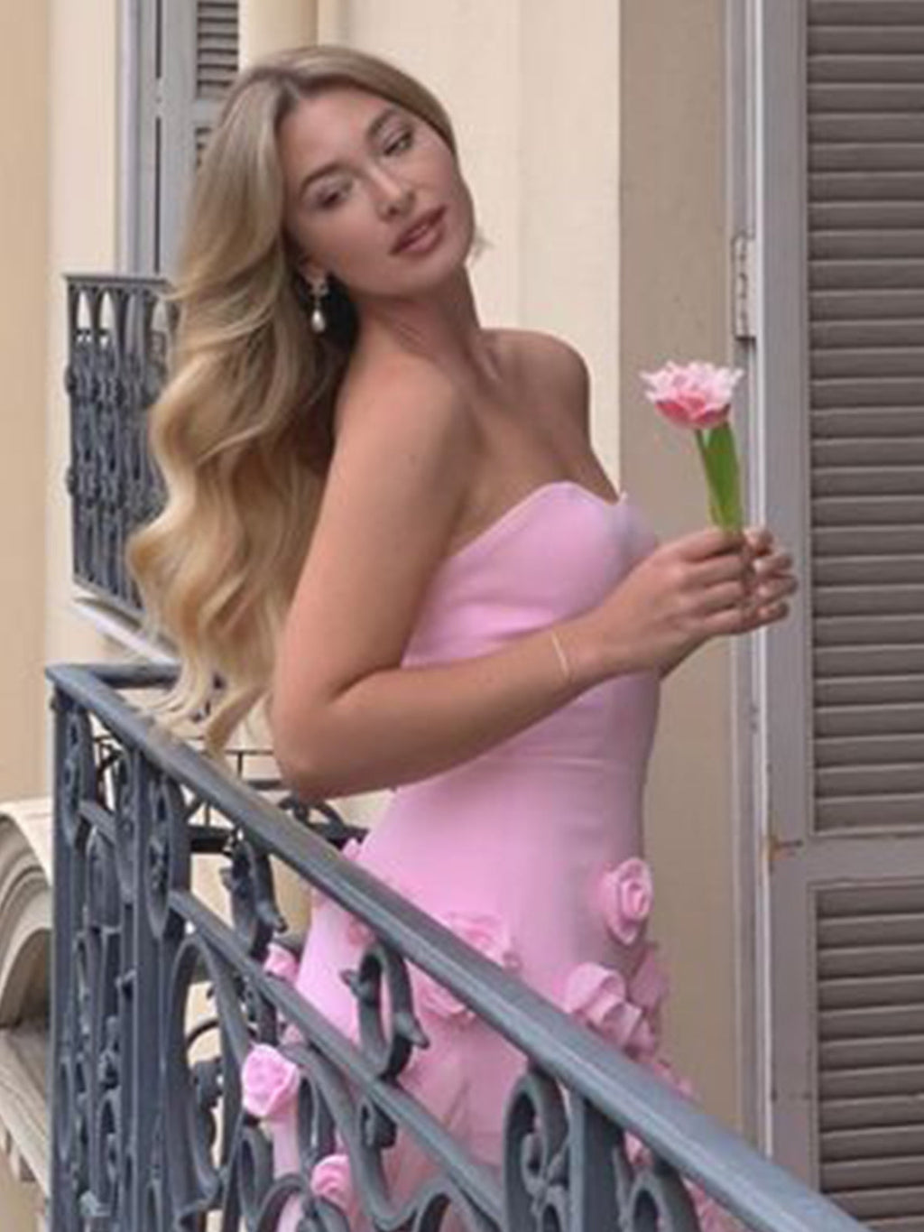 Vestido de fiesta rosa con escote corazón, sin mangas, corte asimétrico y flores.