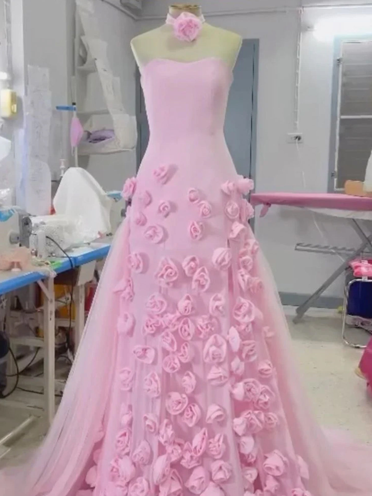 Vestido de fiesta rosa con escote corazón, sin mangas, corte asimétrico y flores.