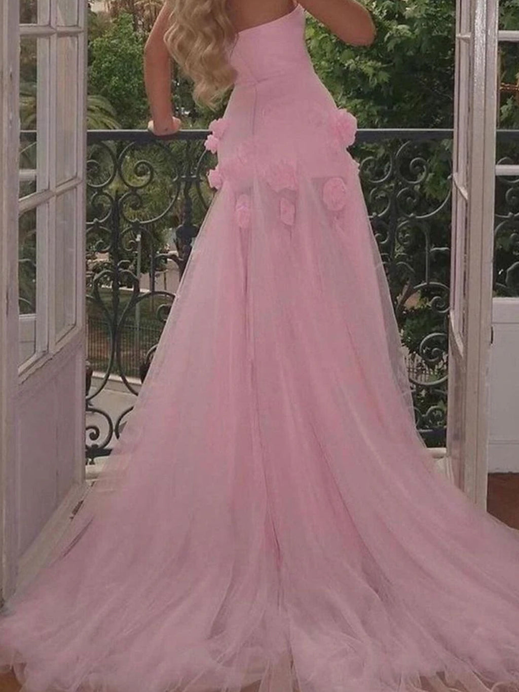 Vestido de fiesta rosa con escote corazón, sin mangas, corte asimétrico y flores.
