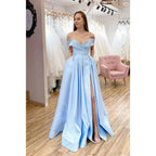 Vestido largo de fiesta de corte A, color azul celeste satinado, con hombros descubiertos, abertura alta y bolsillos. 
