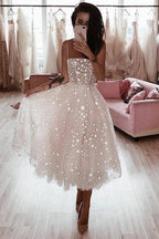 Vestido de fiesta rosa perla con tirantes finos, corte en A y largo hasta la rodilla, con cuentas.