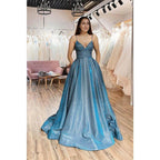 Vestido largo de fiesta de tul brillante con tirantes finos, corte en A y bolsillos. 