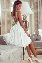 Vestido de fiesta blanco de encaje con tirantes, espalda descubierta y corte en A, con apliques.