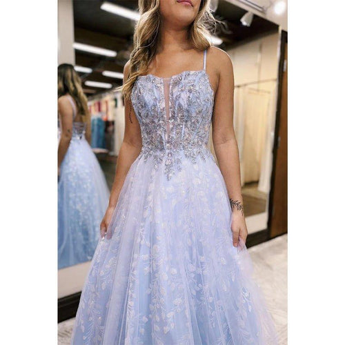 Vestido largo de fiesta con tirantes en línea A, apliques lilas y efecto ilusión.