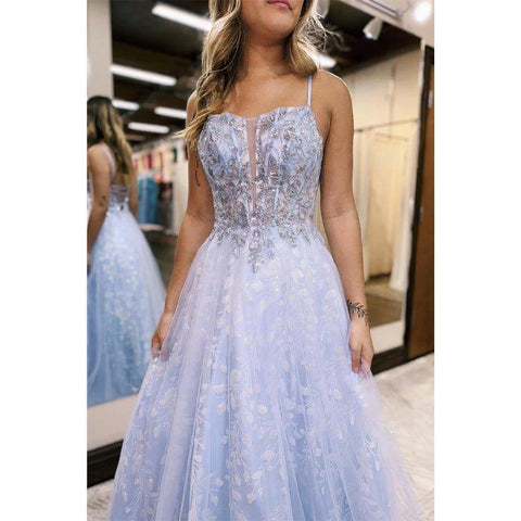 Vestido largo de fiesta con tirantes en línea A, apliques lilas y efecto ilusión.