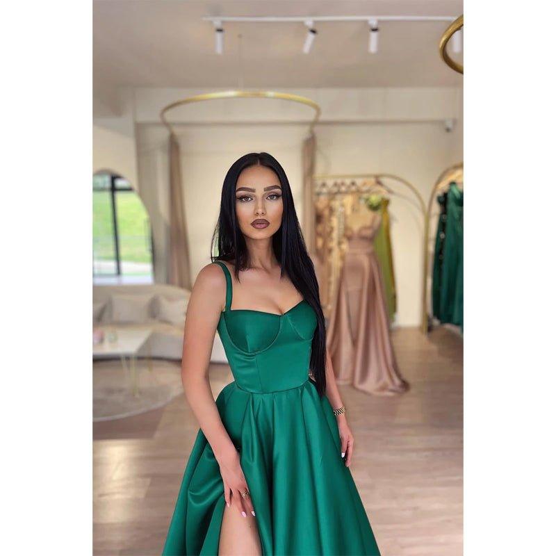 Vestido largo de fiesta verde, corte línea A, escote corazón, abertura alta y bolsillos.