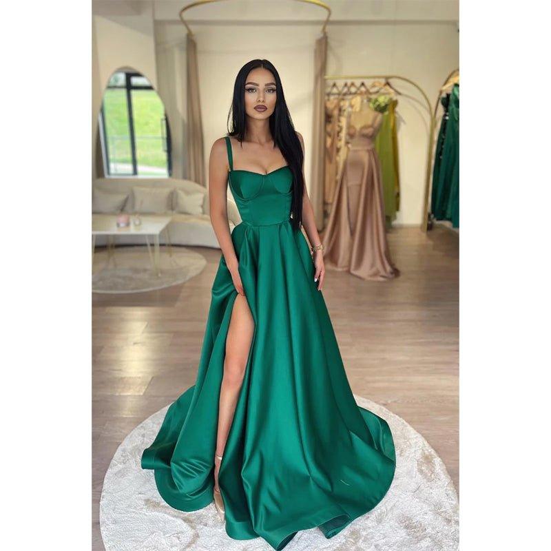 Vestido largo de fiesta verde, corte línea A, escote corazón, abertura alta y bolsillos.