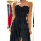 Vestido de noche formal negro de gasa con escote corazón, apliques de encaje y abertura alta. 