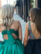 Vestido corto de graduación verde satinado con escote en V, corte en A, bolsillos y espalda descubierta.