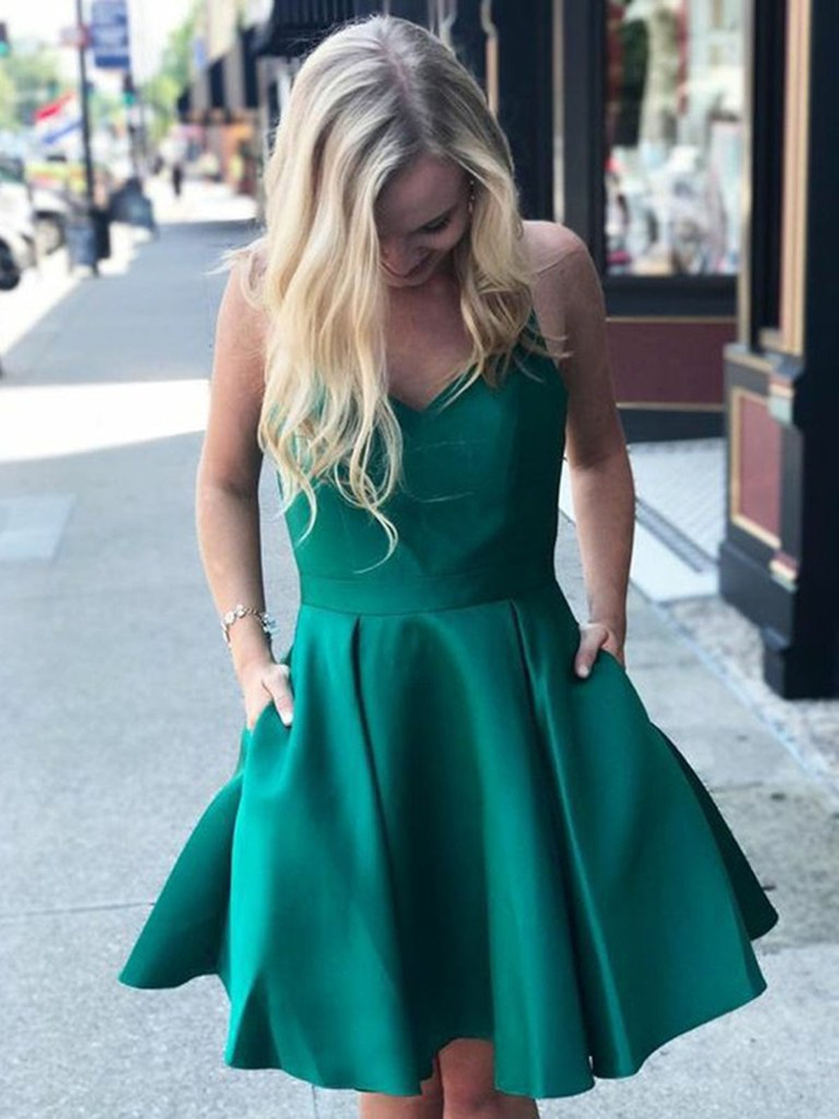 Vestido corto de graduación verde satinado con escote en V, corte en A, bolsillos y espalda descubierta.