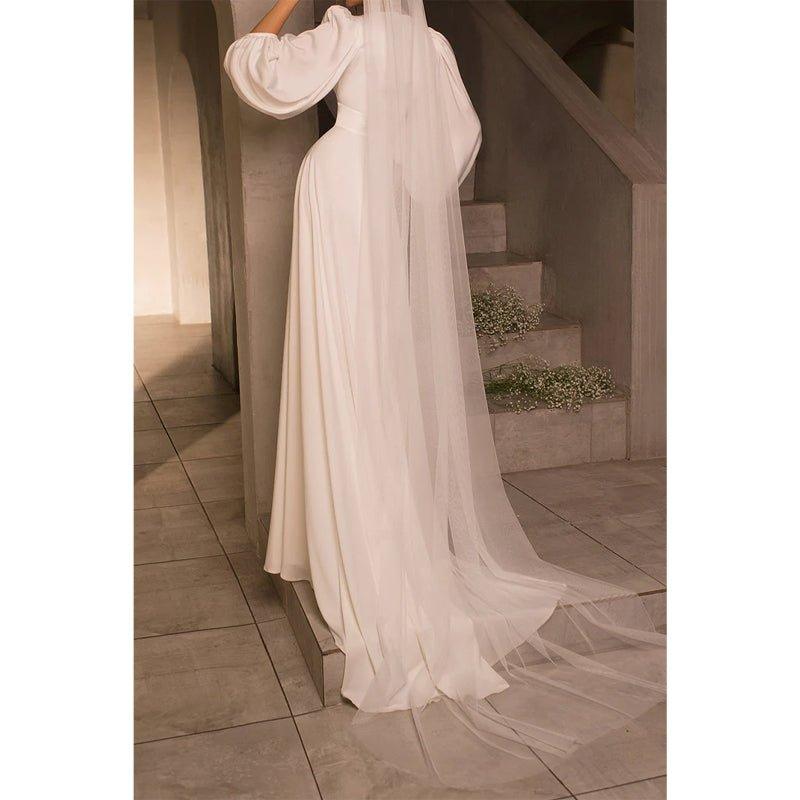 Vestido de novia sencillo de satén, corte en A, escote en V, mangas largas y cola corta. 