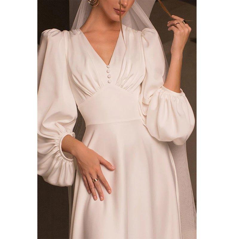 Vestido de novia sencillo de satén, corte en A, escote en V, mangas largas y cola corta. 