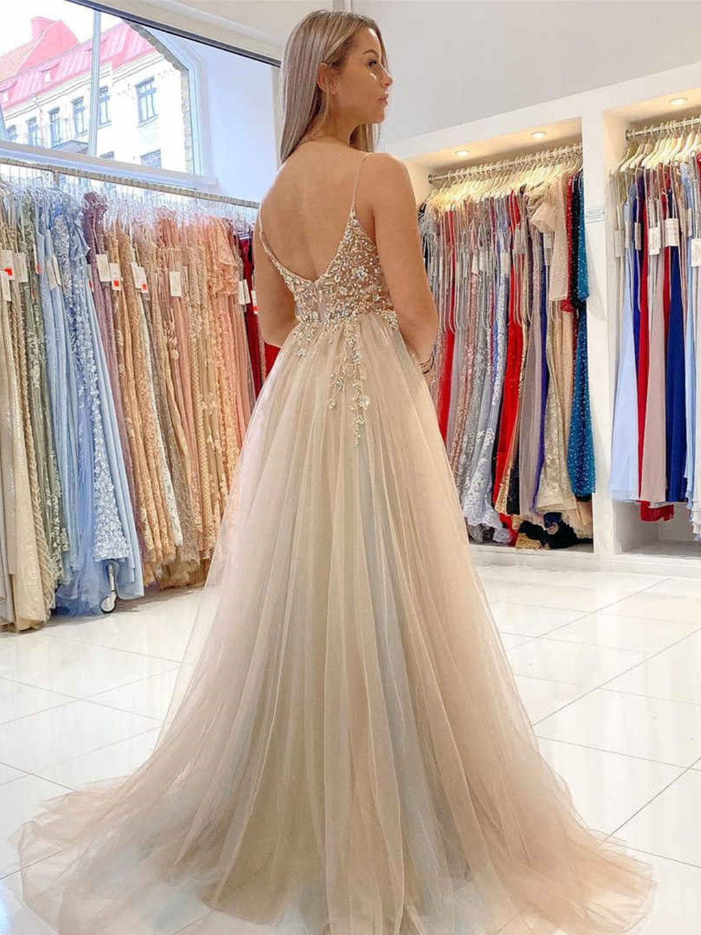 Vestido largo de fiesta gris de corte evasé, con escote en V, espalda descubierta, tul y cuentas, con abertura alta.