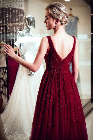 Robe de soirée bordeaux à sequins en tulle et col V sans manches, coupe trapèze, sans manches.