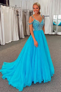 Vestido largo de fiesta azul con escote barco y detalles de pedrería.