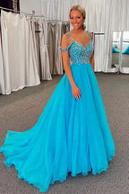 Vestido largo de fiesta azul con escote barco y detalles de pedrería.