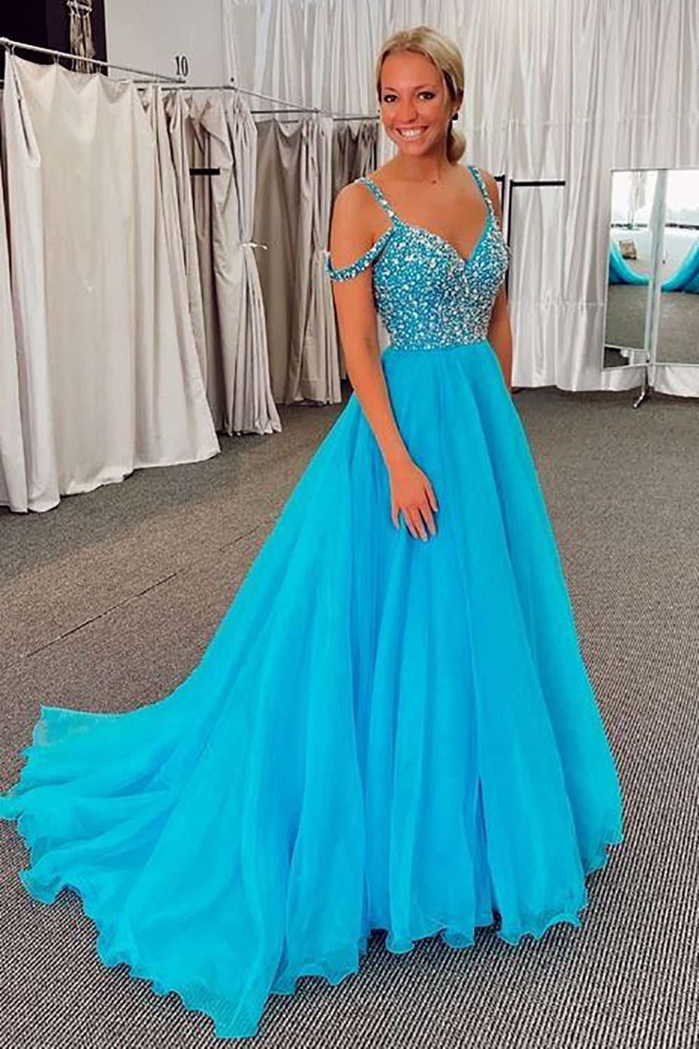 Vestido largo de fiesta azul con escote barco y detalles de pedrería.