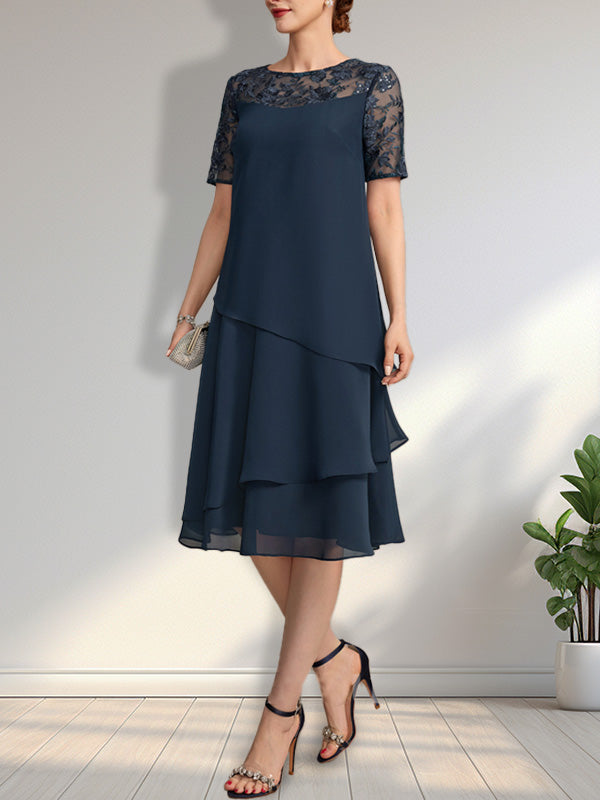 Vestido de novia de corte línea A con escote ilusión, largo hasta la rodilla, de encaje y gasa con lentejuelas.
