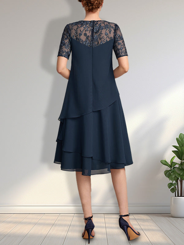 Vestido de novia de corte línea A con escote ilusión, largo hasta la rodilla, de encaje y gasa con lentejuelas.