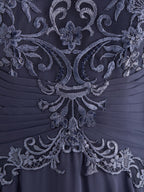 Robe de mère de la mariée en mousseline de soie et dentelle, coupe trapèze, longueur au sol, décolleté illusion, ornée de sequins plissés
