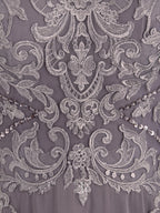 Robe de mère de la mariée asymétrique en mousseline de soie et dentelle, coupe trapèze, col bateau illusion, ornée de sequins et de perles.